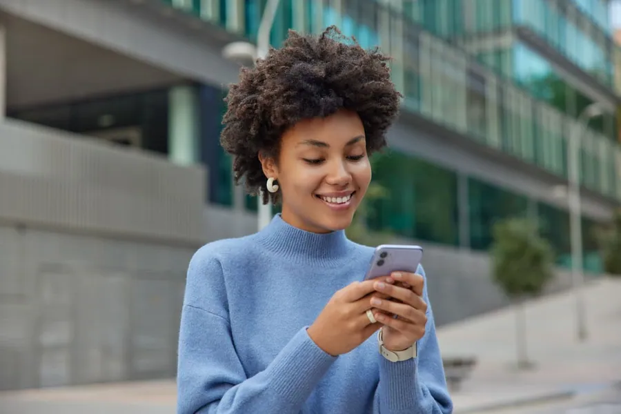 Colaboradora conferindo o valor de coparticipação no celular